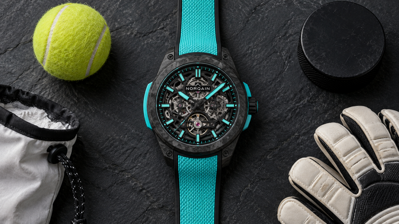 ノルケイン ワイルドワン スケルトン 42mm ターコイズと、テニスボールやパックなどアスリートを連想させる小物を並べた俯瞰写真